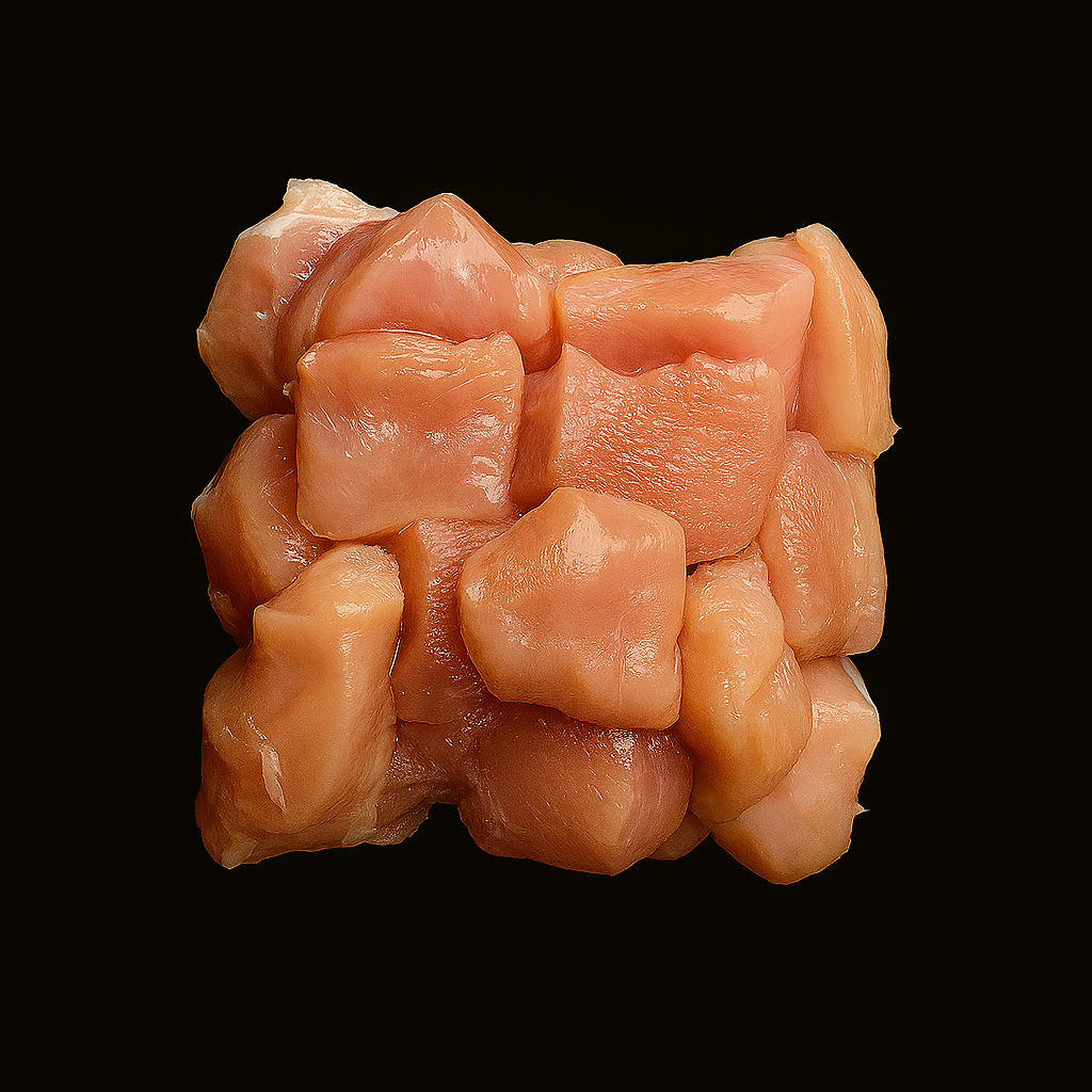 Raw fresh chicken cubes, pale pink and evenly diced, arranged on white tray with minimal garnish