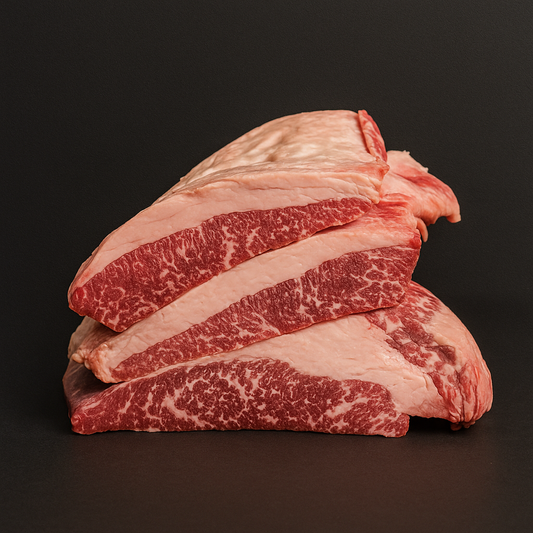 Raw Angus brisket MB3+, whole cut with moderate marbling and intact fat cap, placed on butcher tray