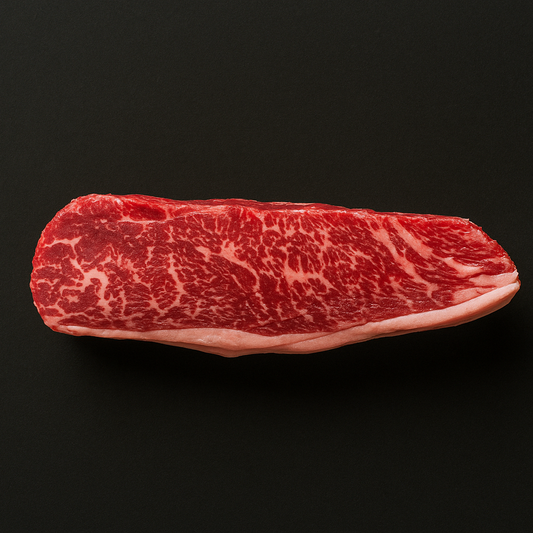 Raw Wagyu picanha MB 4/5, thick-cut with moderate marbling and intact fat cap, placed on butcher tray