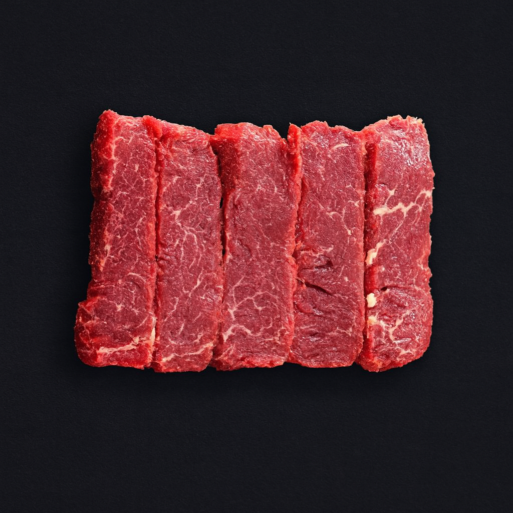 Thinly sliced veal shabu chapo, pale pink with fine marbling, arranged in overlapping layers on chilled tray